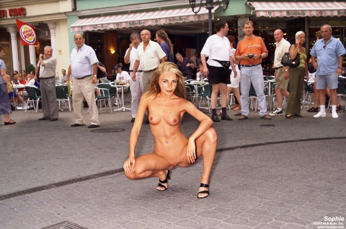 Naked woman on the street with men