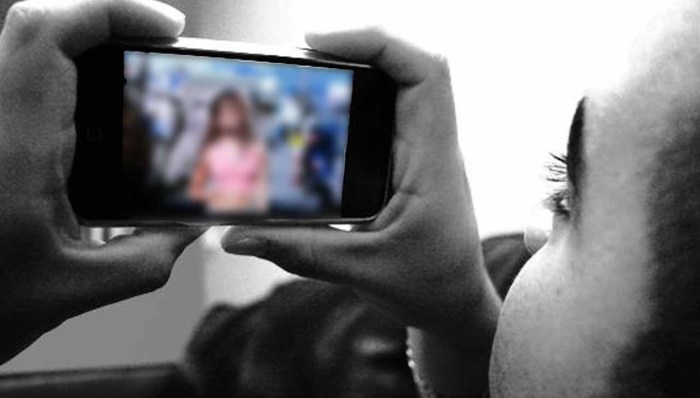 The girl holds the phone with her feet