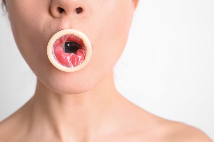 Girl with a condom in her mouth
