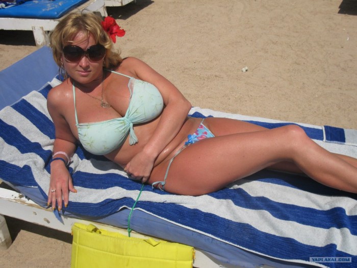 An adult woman sunbathes