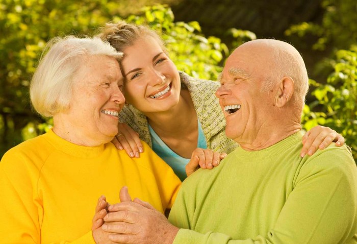 An elderly couple sits on a bench