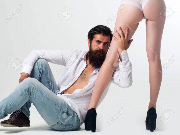 A man sits at the feet of a woman