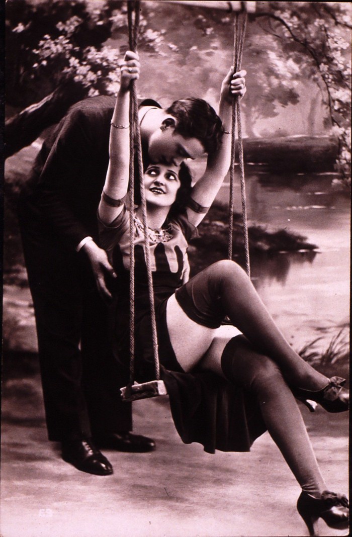 A man behind the woman holds the woman by the chest