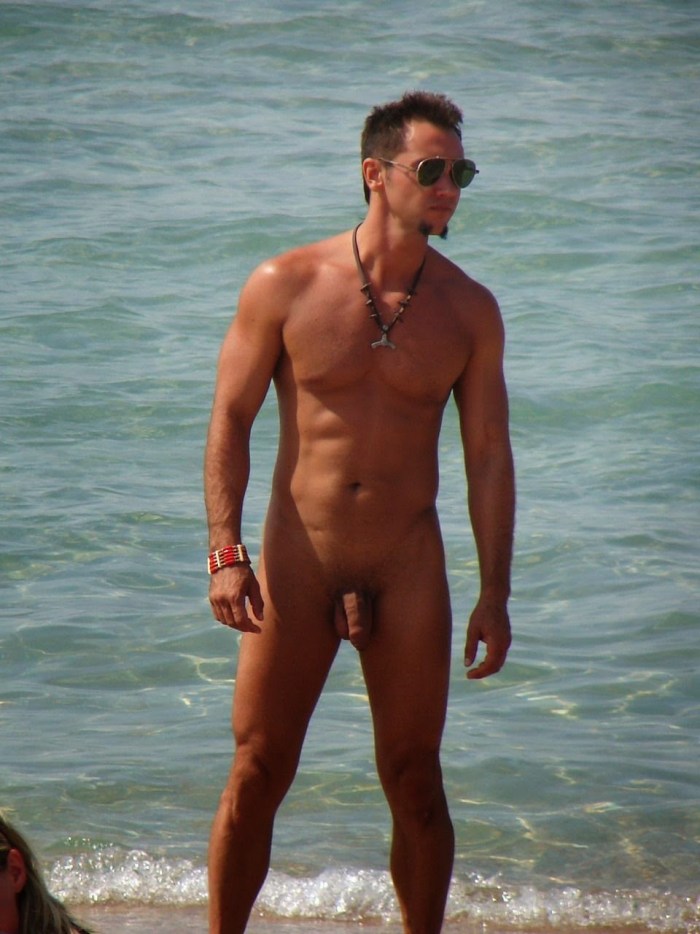 A naked guy lies on the beach