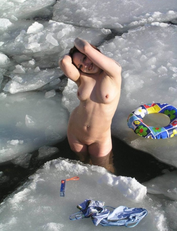 Naked woman bathes in winter