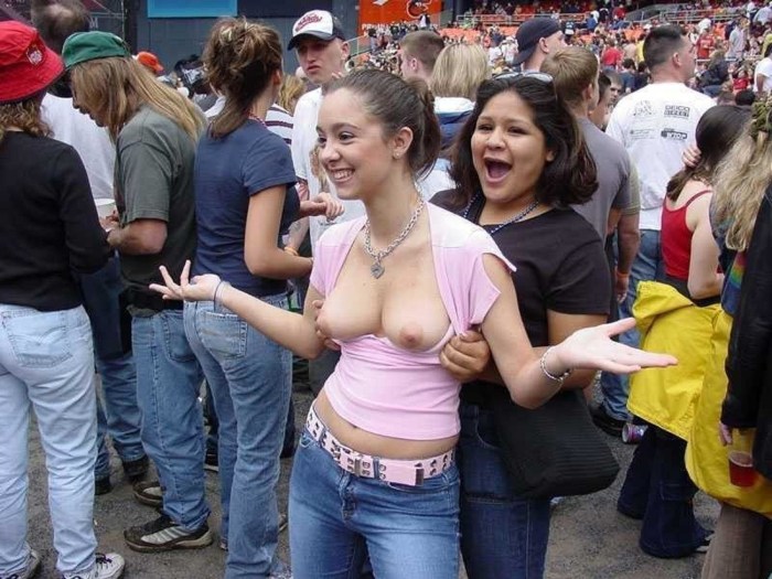 The girl shows her breasts in a public place