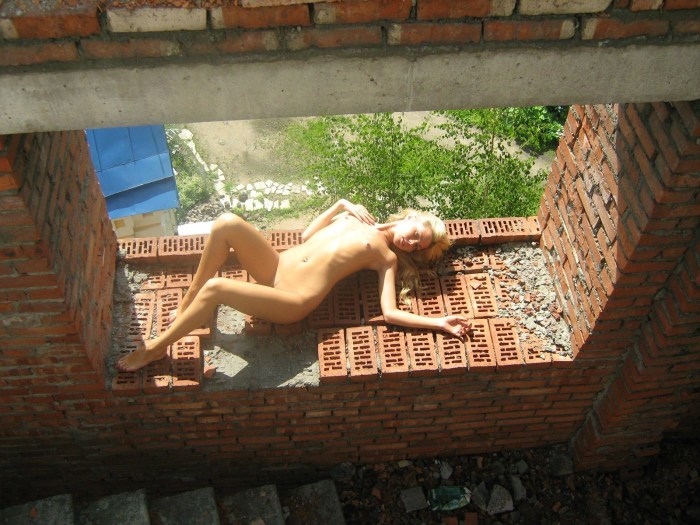 Naked blonde at a construction site